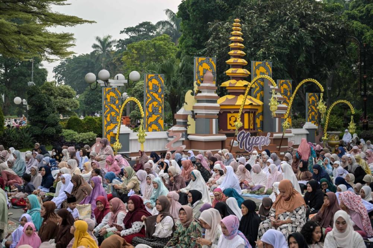 Devotees listen to a preacher's sermon after attending the Eid al-Fitr prayers at city hall in Surabaya on March 21, 2026, marking the end of holy month of Ramadan. (AFP)