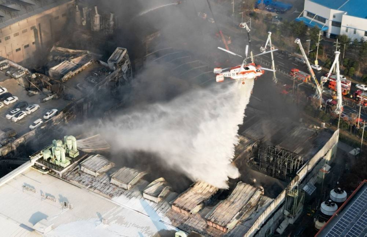A firefighting helicopter drops water to extinguish a fire at a car parts plant in Daejeon on Friday. (AFP)
