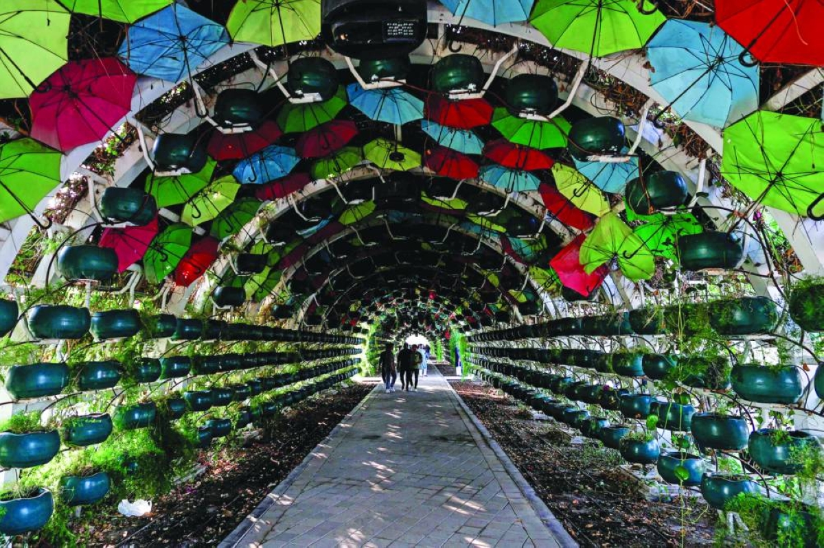 Residents walk under the shade near the Corniche, on the second day of Eid al-Fitr celebrations. – AFP