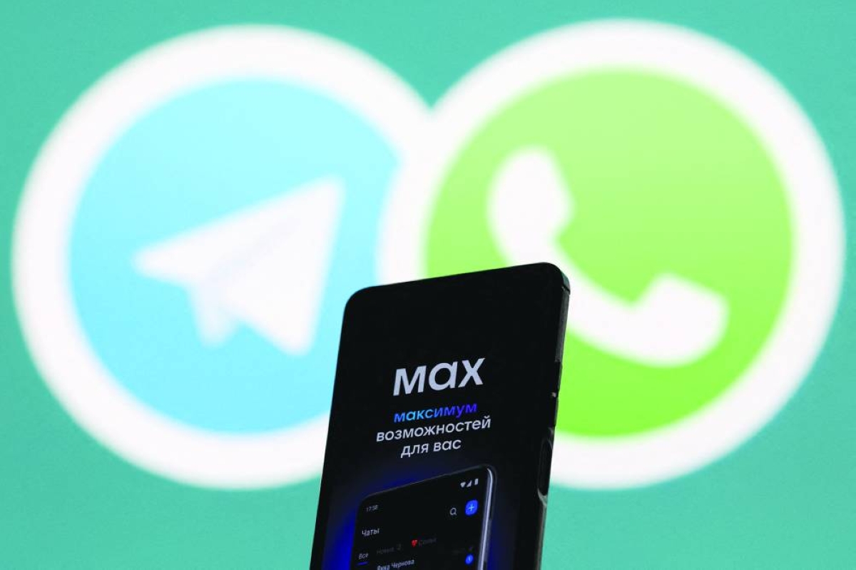 
File photo shows a web page of the Russian messenger app Max displayed on a smartphone next to a screen showing the logo of WhatsApp and Telegram applications. (Reuters) 