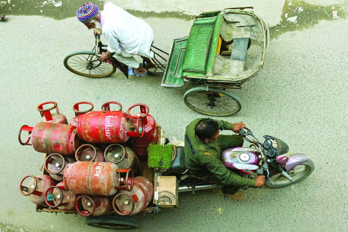 A delivery man transports liquid petroleum gas (LPG) cylinders in Amritsar Tuesday. (AFP)