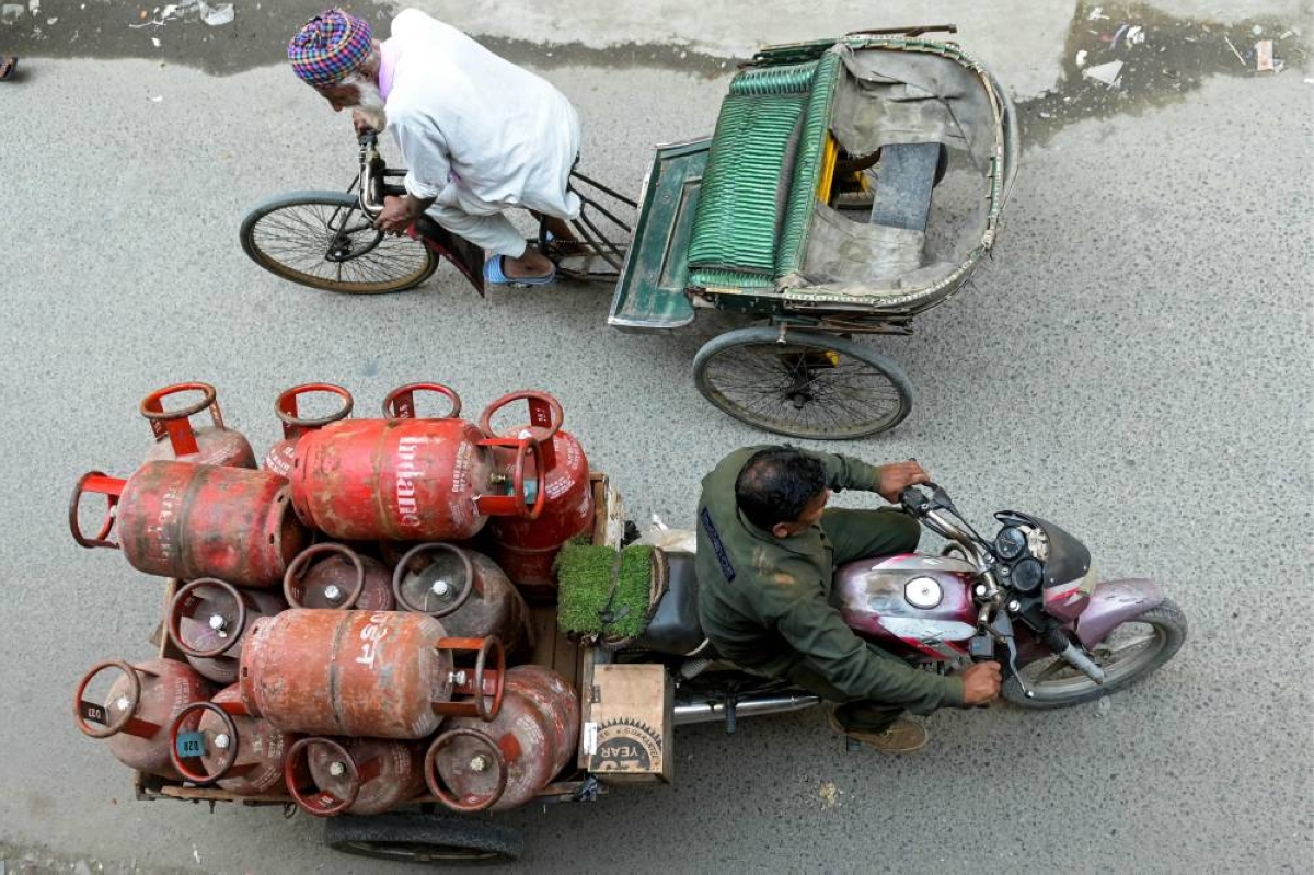 A delivery man transports liquid petroleum gas (LPG) cylinders in Amritsar yesterday. (AFP)