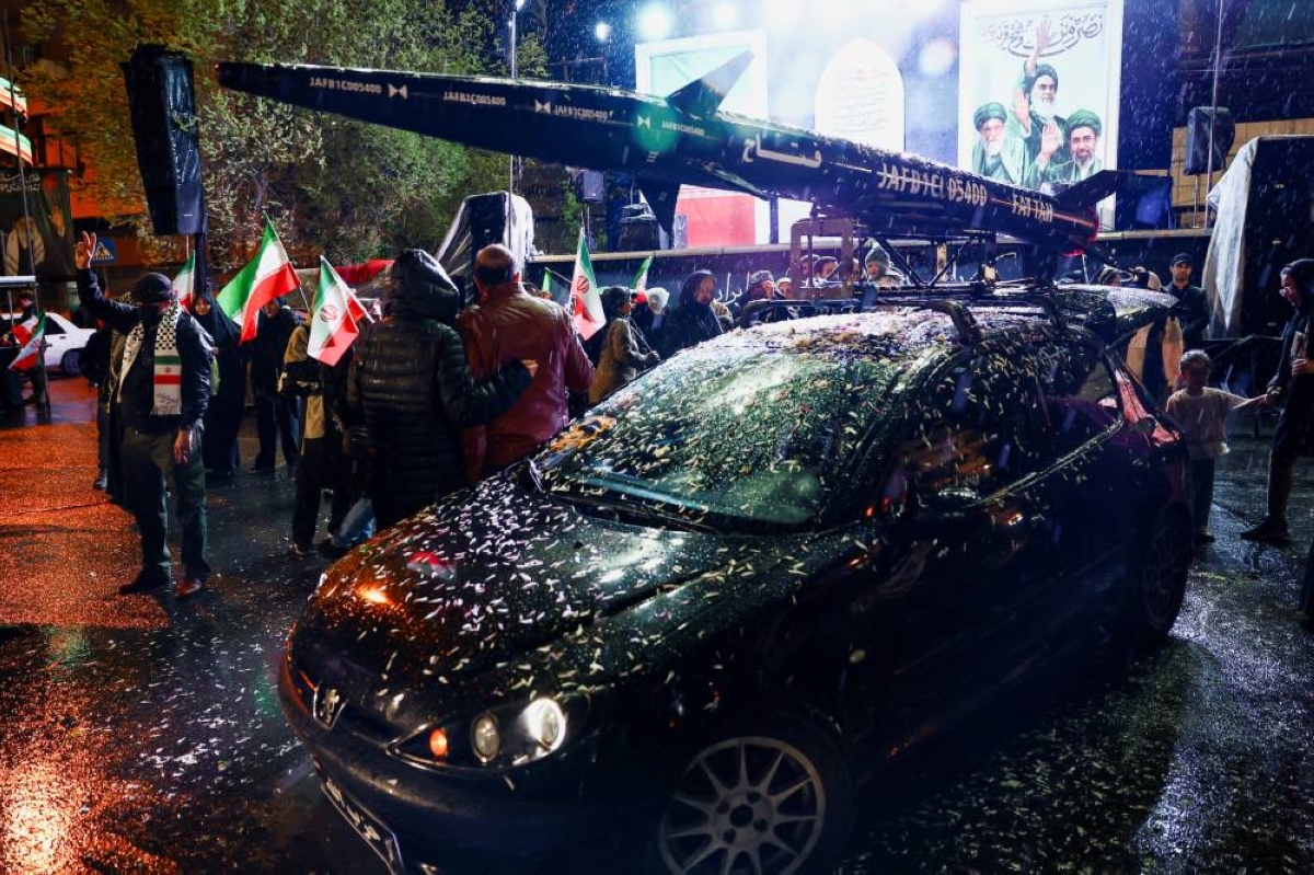 A symbolic mock-up of an Iranian missile is mounted on a car during a rally in Tehran yesterday. – Reuters