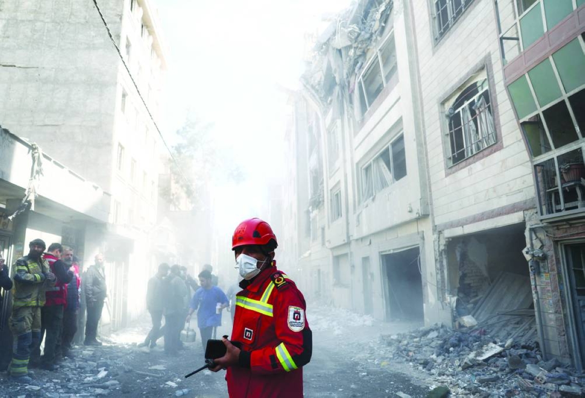 Emergency responders inspect the site of a residential building in Tehran that was damaged in an air strike. – Reuters