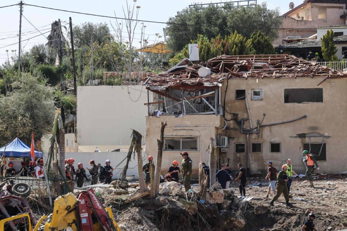 First responders assess the damage after a house was hit by a projectile strike in Eshtaol, near Beit Shemesh in central Israel, yesterday. (AFP)