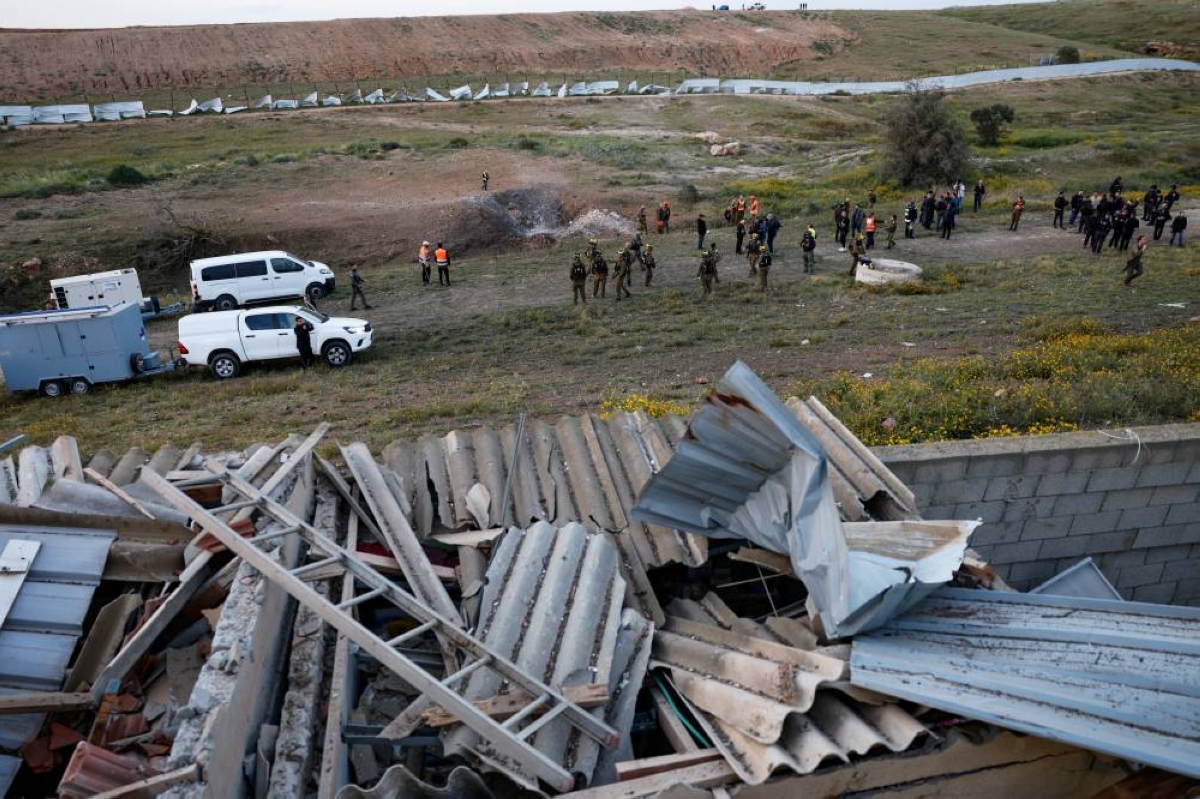 Emergency personnel work at an impact site following an Iranian missile strike, as the US-Israeli conflict with Iran continues, in southern Israel, yesterday. (Reuters)
