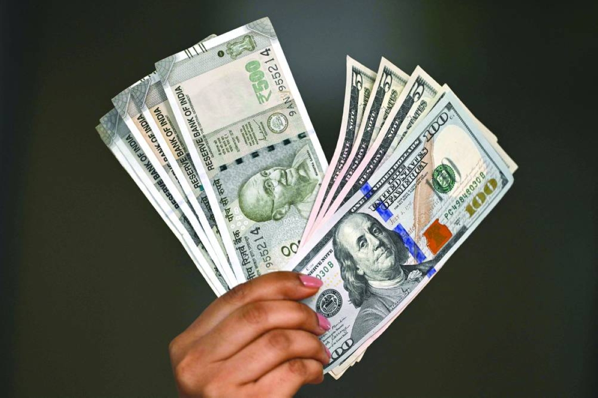 Indian rupee and US dollar currency notes are held by a foreign exchange employee at an office in New Delhi. Asian currencies — some already struggling — have come under heavy selling, putting them among the largest losers globally. 