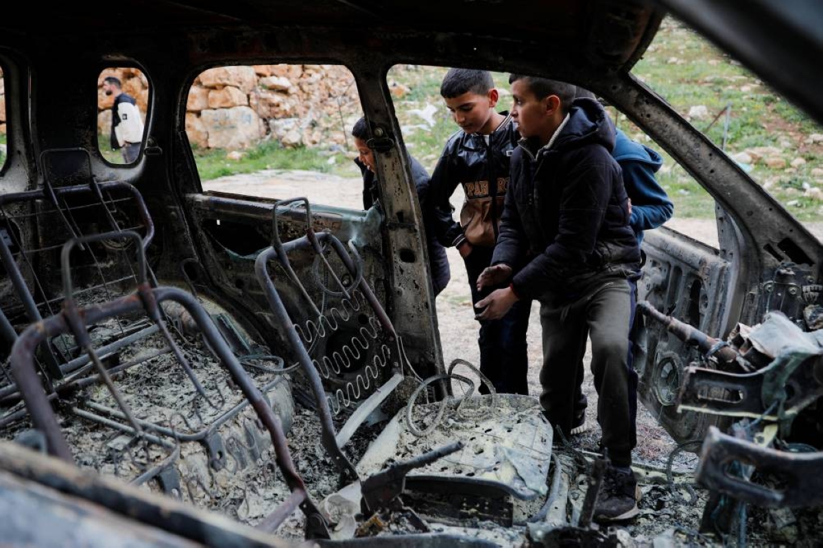 People check damaged cars, which Palestinians say was burned by Israeli settlers, near Hebron in the Israeli-occupied West Bank March 30, 2026. REUTERS/Yosri Aljamal