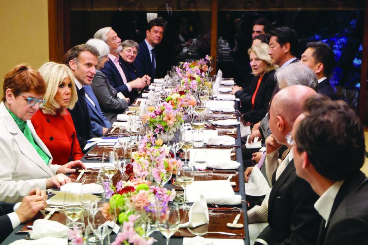 French President Emmanuel Macron (third left) and his wife Brigitte Macron (second left) attend a dinner at Happo-en in Tokyo Tuesday. (AFP)
