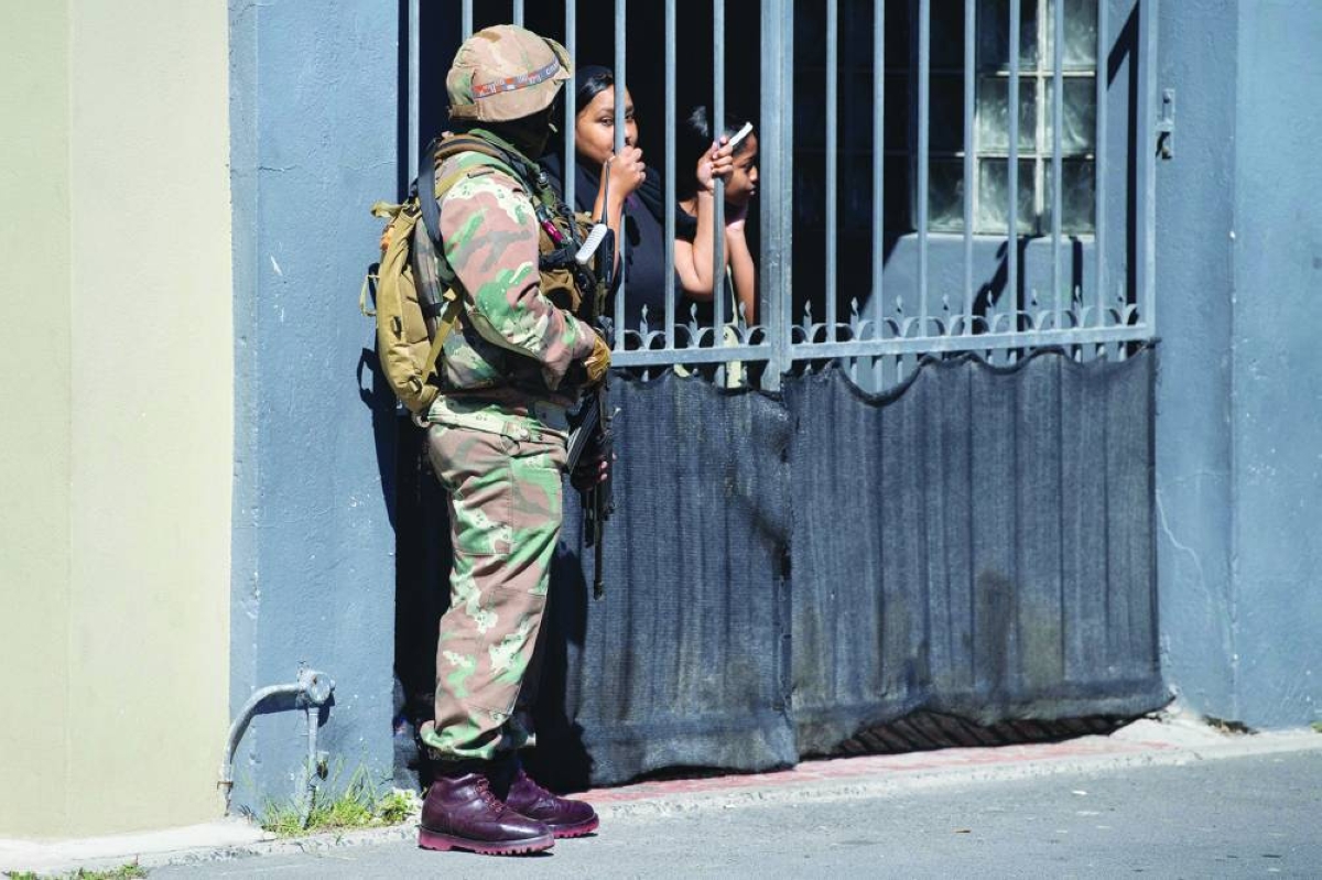 Residents watch soldiers of the South African National Defence Force(SANDF) on a patrol as part of Operation Prosper in Mitchells Plain, near Cape Town, Wednesday. (AFP)
