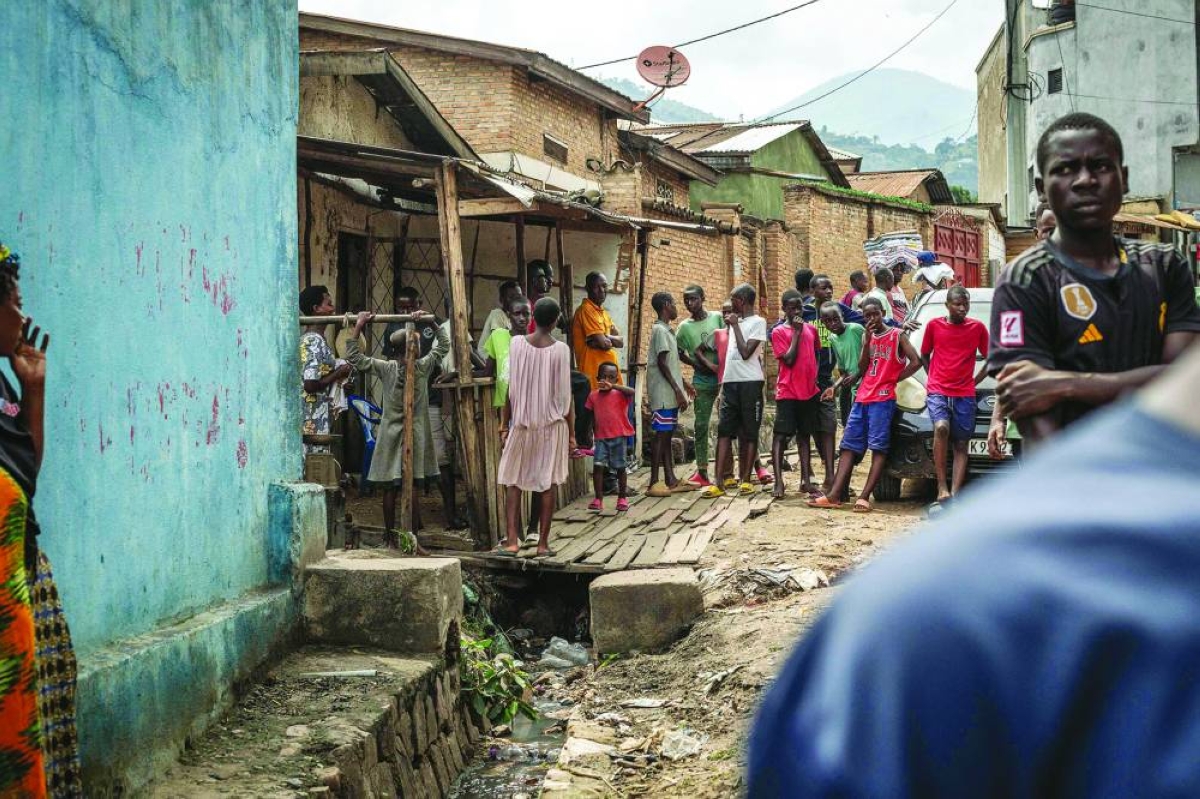 Residents gather to assess damage at the site where a person died following explosions after a fire at a military arsenal in the Musaga district of Bujumbura, Wednesday.  (AFP)