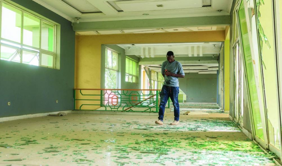 A worker inspects the debris of broken window glass after the impact following the explosions at a military ammunition store with the blasts lasting several hours, according to comments from residents, prompting terrified residents to seek shelter, within Rumonge Road in Kinindo Neighbourhood of Bujumbura, Burundi, Wednesday. (Reuters)