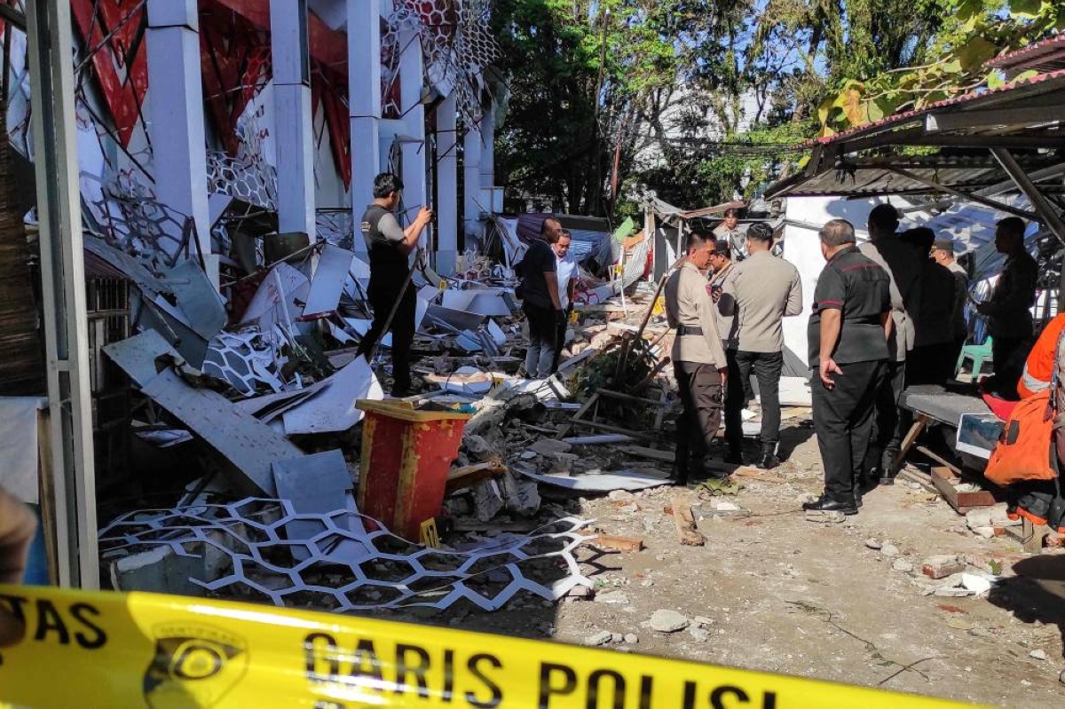 Police officers look at a building of the North Sumatra's National Sports Committee of Indonesia  damaged following a severe 7.4-magnitude offshore quake in Manado, North Sulawesi, Thursday. (AFP)