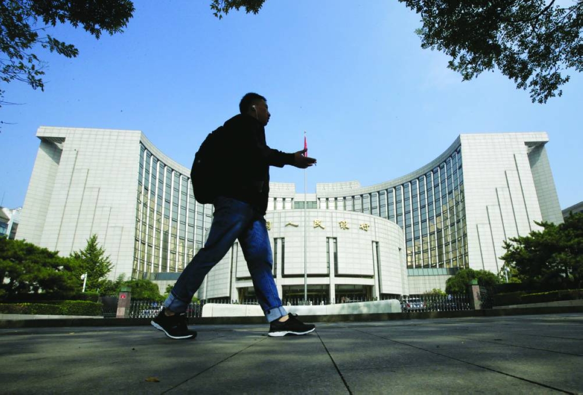 A man walks past the headquarters of the People's Bank of China (PBOC), the central bank, in Beijing. The PBOC drained a total of 890bn yuan ($129bn) worth of liquidity via short-term open market operations in March and soaked up another 250bn yuan through longer-term tools including outright reverse repurchase agreements and medium-term lending facility.