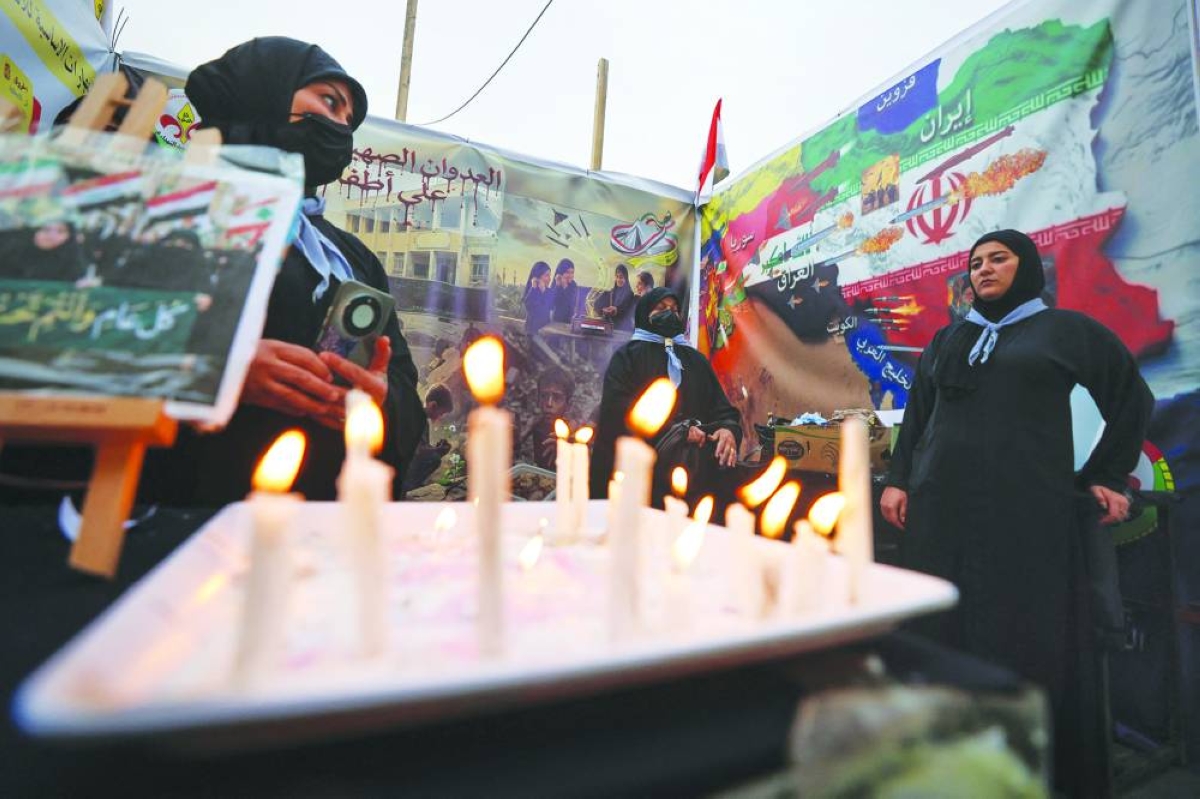 Women light candles in memory of the victims of the US-Israeli attacks on Iran and Lebanon during a rally Thursday in support in Baghdad's Tahrir Square. AFP