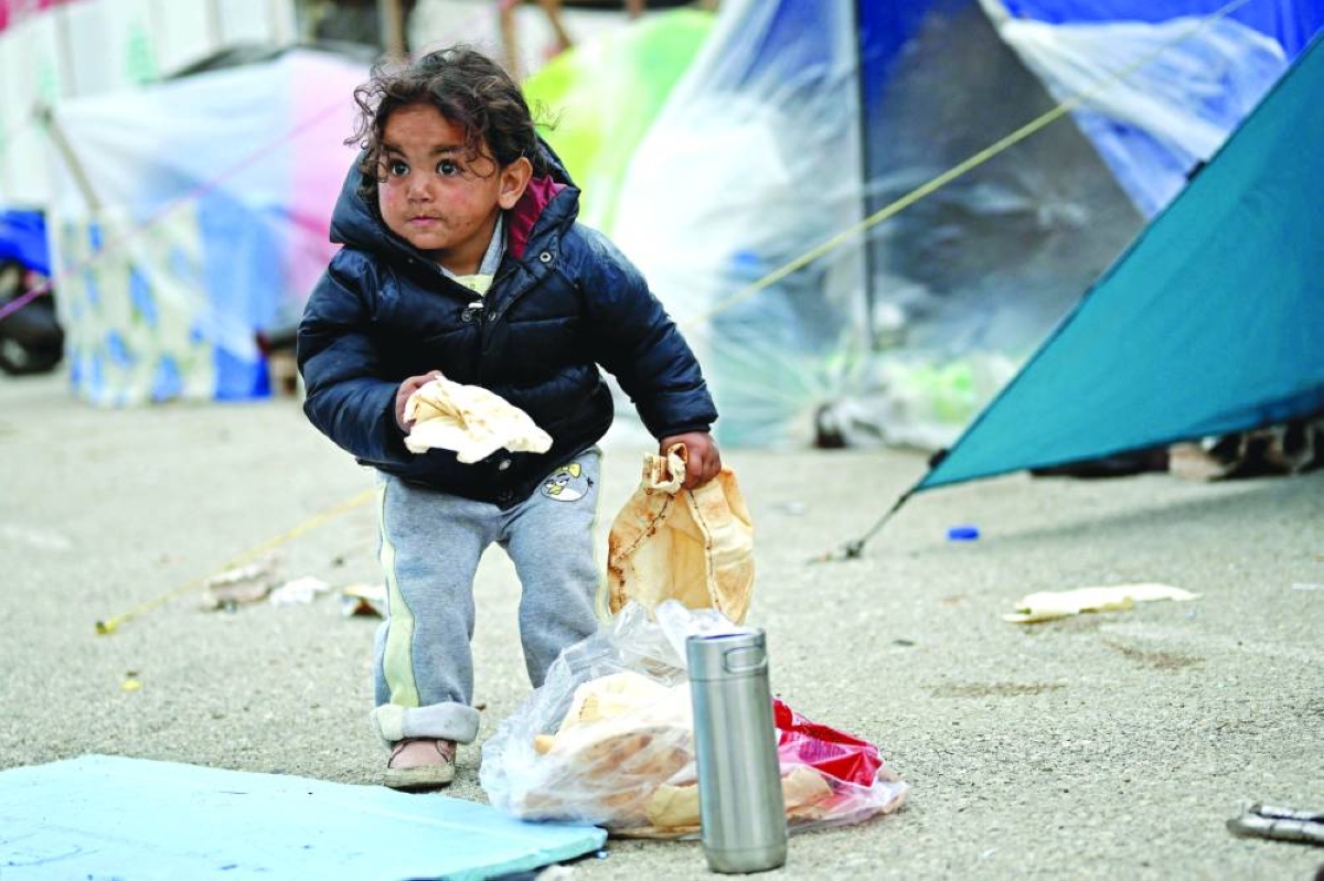 A displaced young girl holds a loaf of bread at an unofficial camp for displaced people on Beirut's waterfront area. AFP