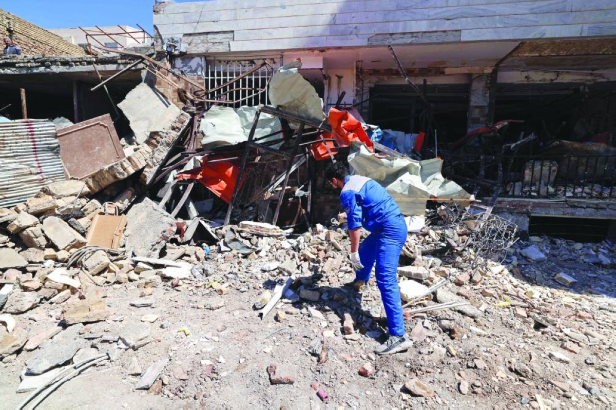 
A man inspects the debris of residential buildings that were damaged by recent strikes at Vahdat town in Karaj, southwest of Tehran, yesterday. (AFP) 