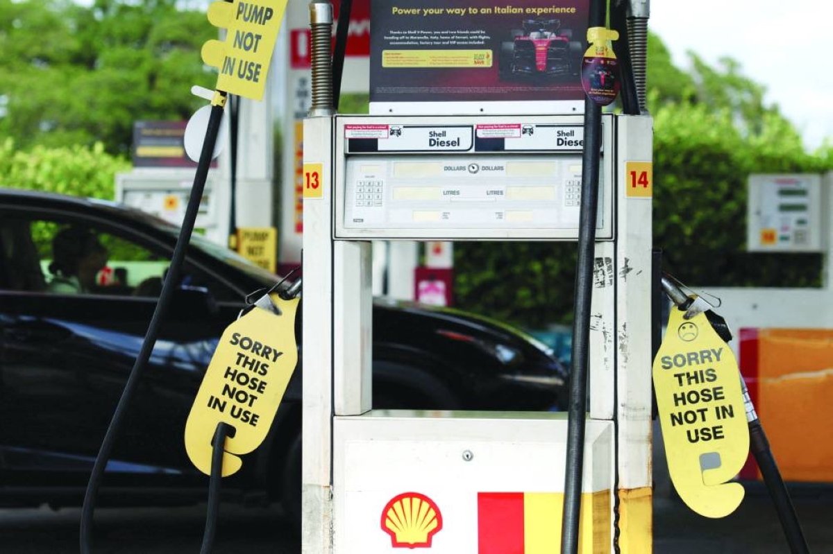 A woman looks at signs displayed on empty fuel dispensers at a Shell petrol station that ran out of fuel, in Sydney, Australia. (Reuters/File Photo)