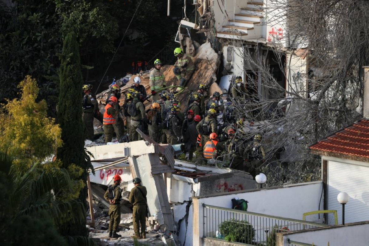 Emergency personnel work at the site of a projectile impact, as the US-Israel conflict with Iran continues, in Haifa, Israel, yesterday. (Reuters)