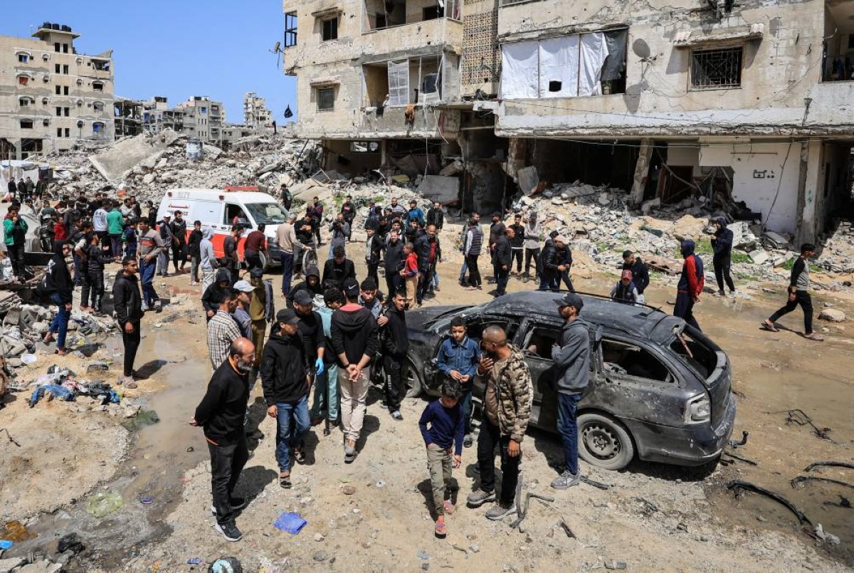 Palestinians inspect the damage after a person was hit by an Israeli strike while riding a bicycle, according to medics, in Gaza City, yesterday. (Reuters)