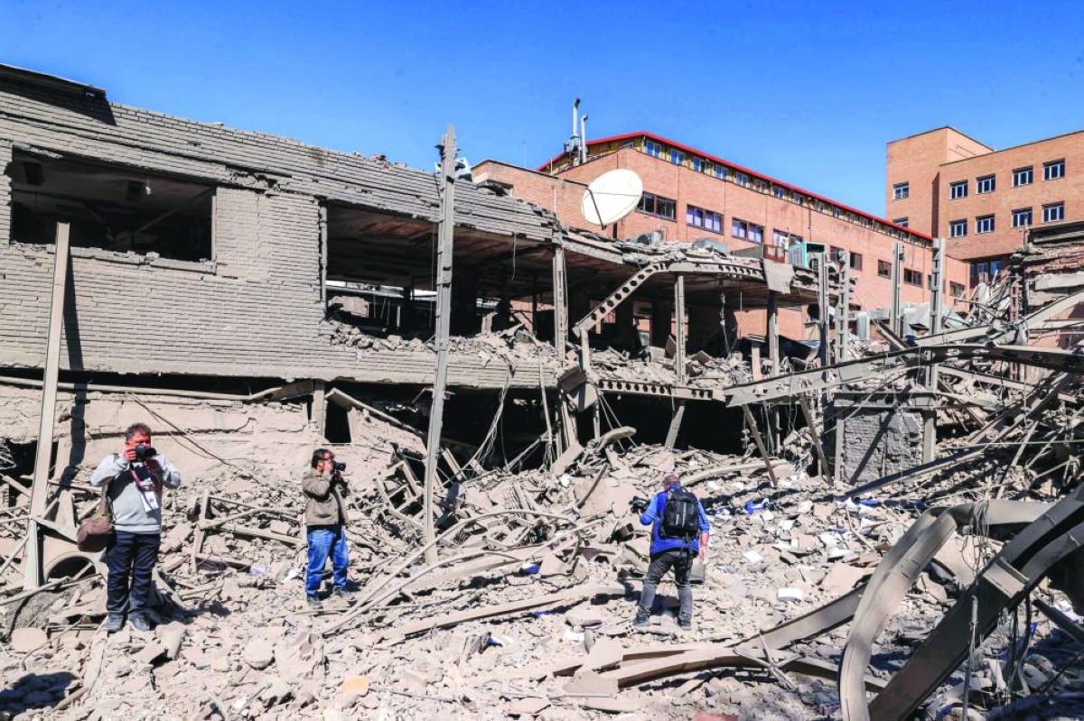 Journalists film at a damaged area following strikes on Sharif University of Technology in Tehran, Tuesday. (AFP)