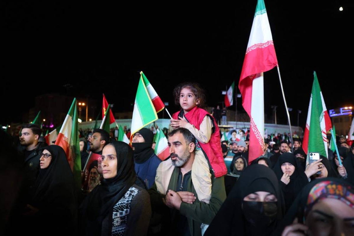 Iranians react after a ceasefire announcement at the Enqelab square, in Tehran, yesterday.(AFP)
