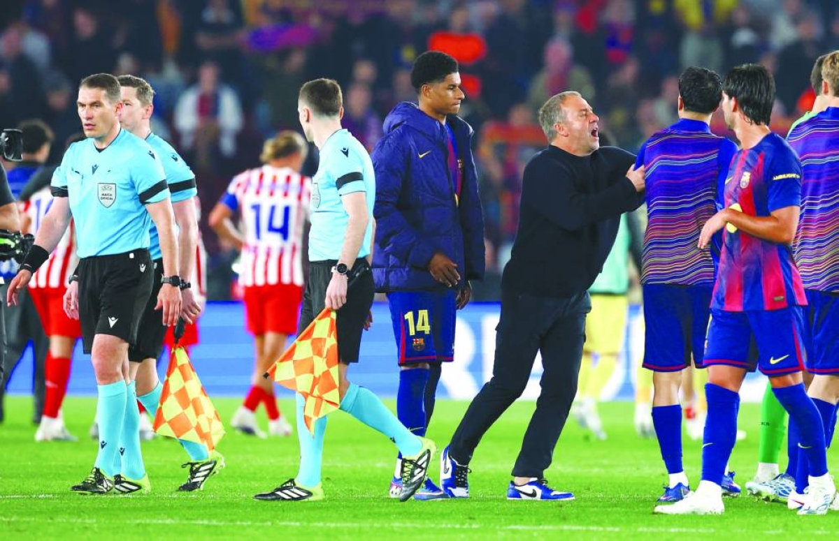 
Barcelona coach Hansi Flick pushes away defender Joao Cancelo from referees after their loss to Atletico Madrid at the Camp Nou in Barcelona on Wednesday. (Reuters) 