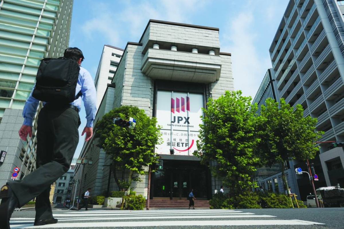 A pedestrian crosses the road in front of the Tokyo Stock Exchange. The Nikkei 225 closed up 1.8% to 56,924.11 points yesterday.