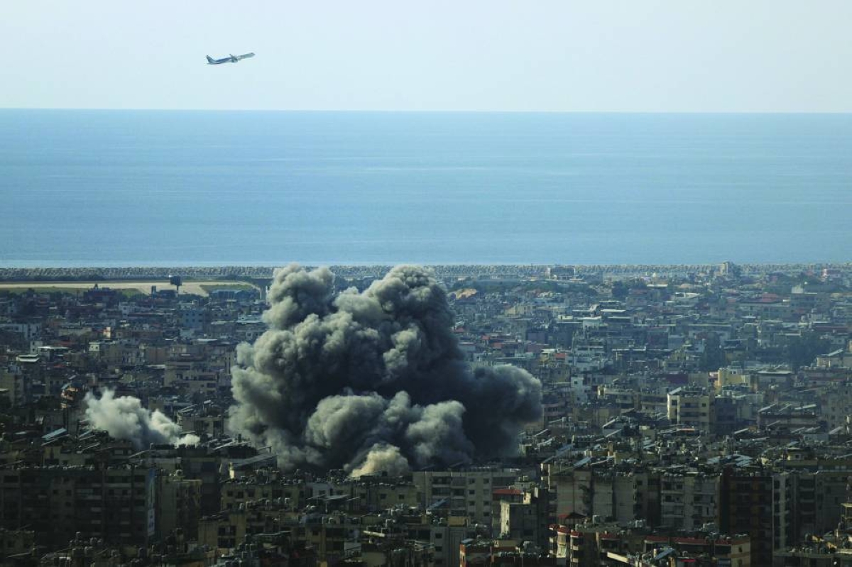 An airplane flies as smoke rises after an Israeli strike on Beirut's southern suburbs, following an escalation between Hezbollah and Israel amid the US-Israeli conflict with Iran, in Lebanon. (Reuters)