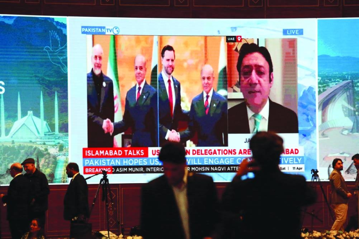 Members of the media work as a screen displays news with images of Pakistan's Prime Minister Shehbaz Sharif meeting with US Vice President JD Vance and separately with Iranian Parliament Speaker Mohammad Bagher Ghalibaf, at a media centre set up for the coverage of the US-Iran peace talks in Islamabad, Pakistan, April 11, 2026. REUTERS