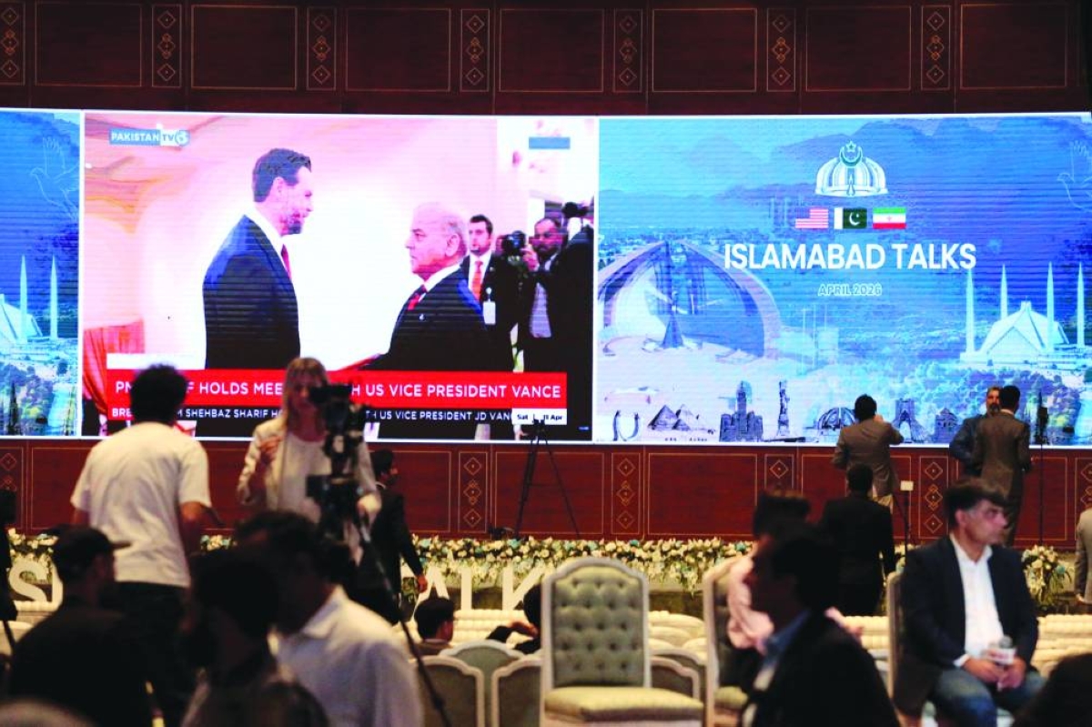 Members of the media work as a screen displays news with an image of Pakistan's Prime Minister Shehbaz Sharif meeting with US Vice President JD Vance, at a media centre set up for the coverage of the US-Iran peace talks in Islamabad Saturday. (Reuters)