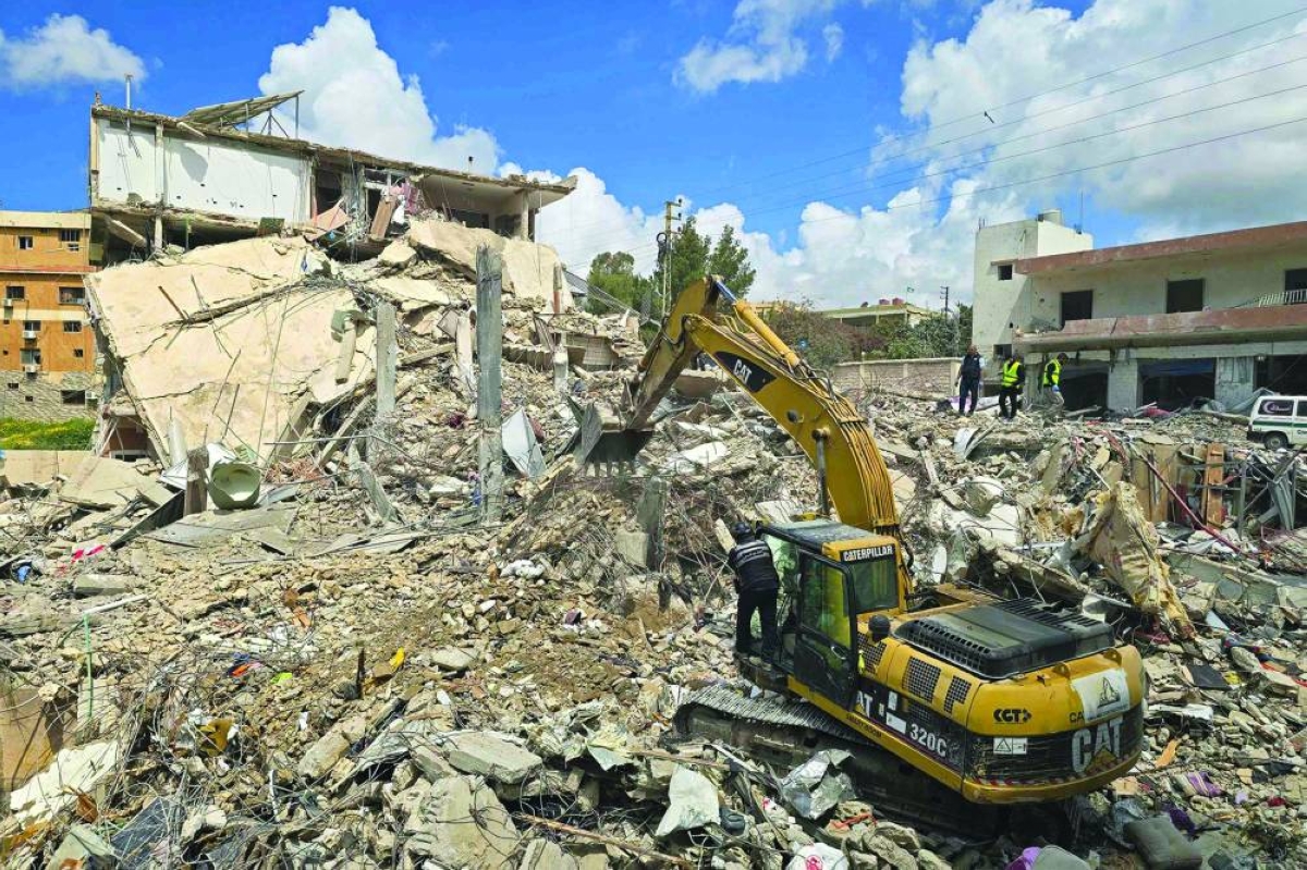 An excavator clears the rubble of destroyed buildings from the site of an Israeli strike that targeted the southern Lebanese village of Qana Sunday. (AFP)