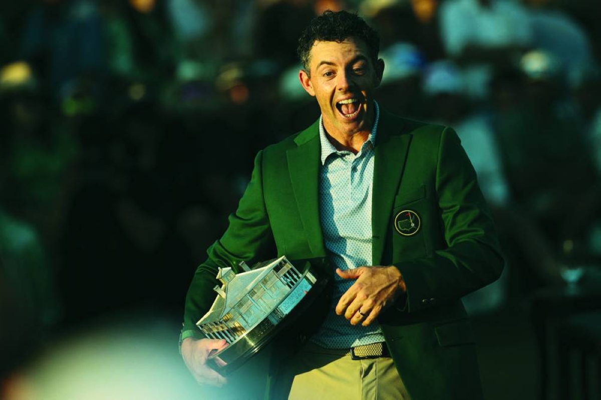 Rory McIlroy of Northern Ireland goes to his daughter (not pictured) while holding the Masters Trophy during the Green Jacket Ceremony after winning during the final round of the 2026 Masters Tournament at Augusta National Golf Club on April 12, 2026 in Augusta, Georgia. AFP