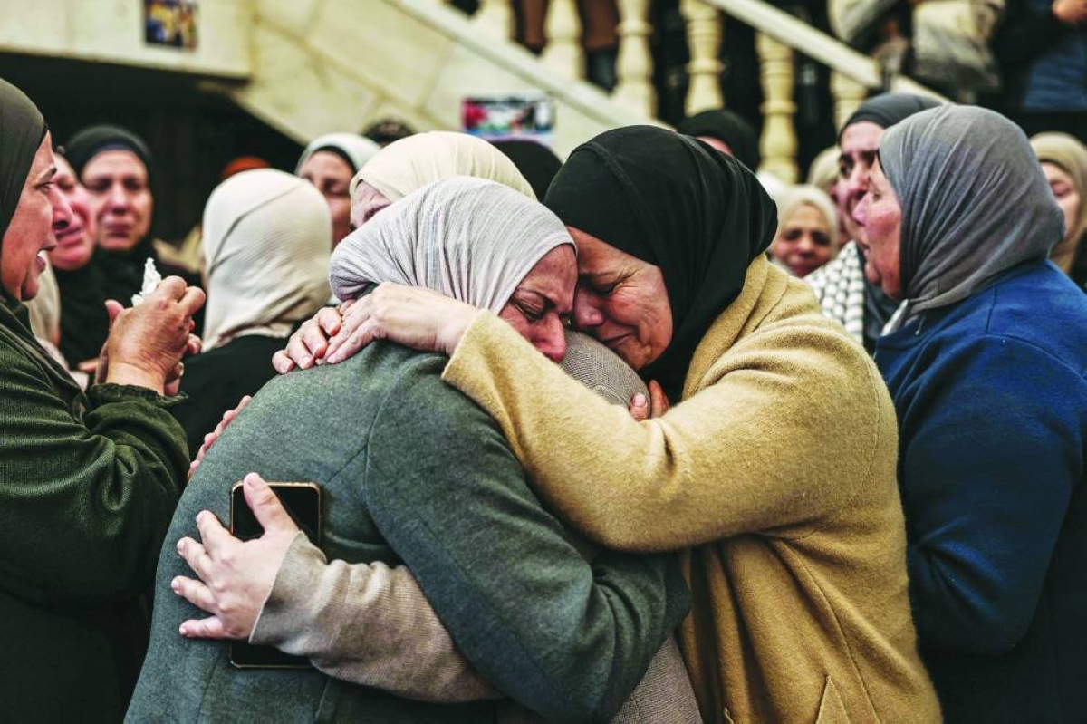 Relatives and friends comfort each other during the funeral of 23-year-old Ali Majed Hamadneh in the village of Deir Jarir, northeast of the city of Ramallah in the occupied Palestinian West Bank, Monday. (AFP)