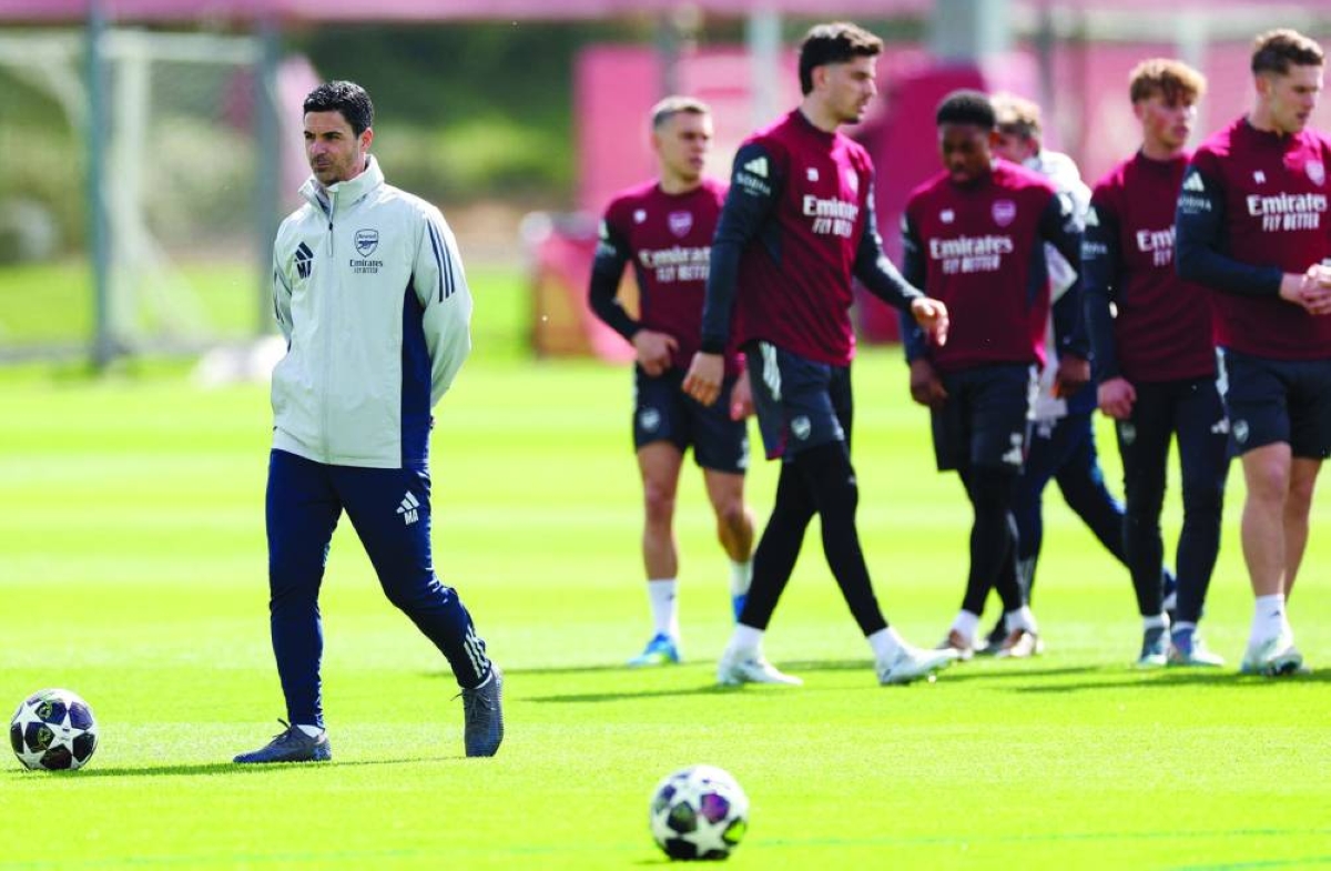Arsenal's Spanish manager Mikel Arteta (L) takes a team training session at London Colney, north of London, on April 14, 2026, on the eve of their UEFA Champions League, quarter-final, second-leg football match against Sporting Lisbon. (AFP)