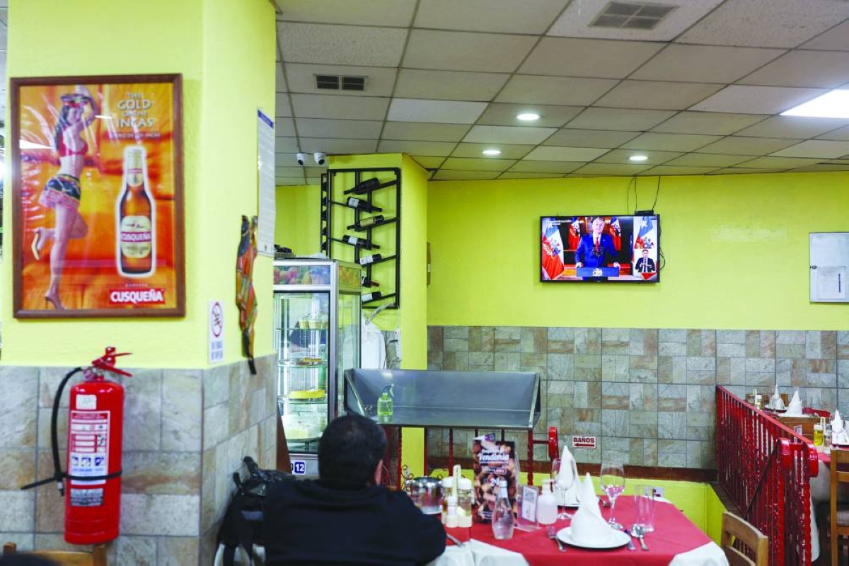 A man watches television in a restaurant while Chile's President, Jose Antonio Kast, delivers economic announcements during a national broadcast, in Santiago, Chile,on Wednesday. (Reuters)
