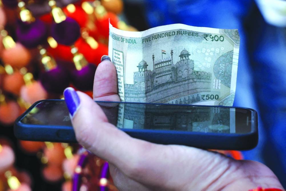 
A woman holds a five-hundred-rupee currency note in the old quarters of Delhi, India. The government is now drawing on its Covid playbook to cushion businesses and consumers hit by gas shortages and soaring oil bills. One such measure could be a credit guarantee scheme worth 2tn-2.5tn rupees ($26.8bn) for small and medium firms and sectors. 