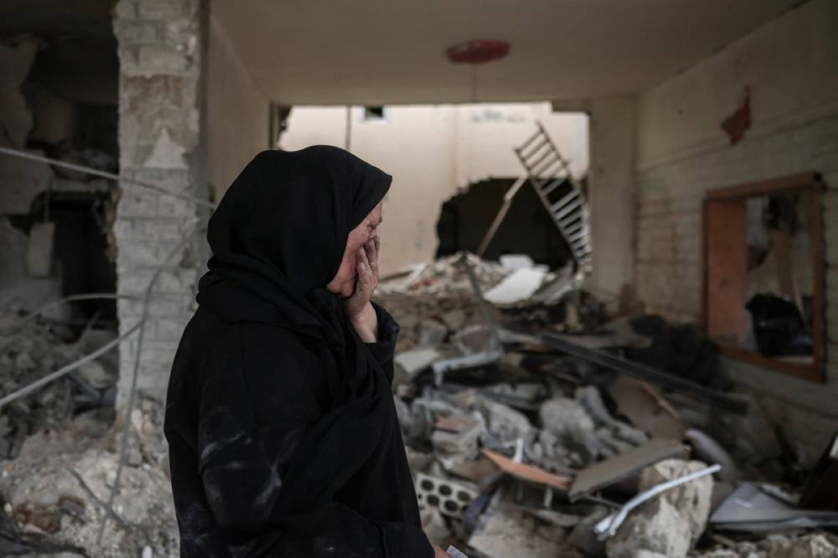 Zahra Eid, 60, who was displaced in Byblos district, reacts while inspecting her house destroyed  by Israeli strikes, after returning to her village, following the ceasefire between Lebanon and Israel, in Tayr Debba, south Lebanon, April 18, 2026. REUTERS/Louisa Gouliamaki