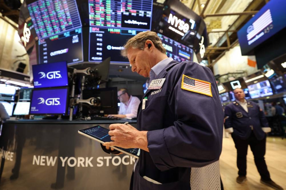 Traders work on the floor of the New York Stock Exchange. The S&P 500 Index has climbed to a record high, brushing off concerns about the potential economic fallout from the Iran war. A surge in energy prices has boosted earnings prospects for oil companies, while renewed optimism over AI spending has boosted sentiment towards some tech stocks. 
