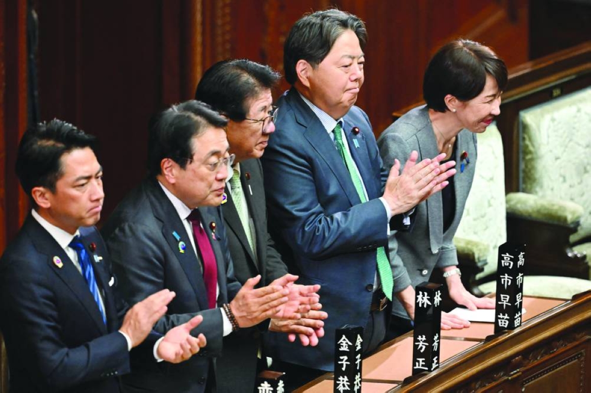 Japan's Prime Minister Sanae Takaichi (right) and her cabinet ministers react after the government's bill to establish a National Intelligence Council was passed by a majority vote of both ruling and opposition parties during a plenary session of the House of Representatives in Tokyo Thursday. (AFP)