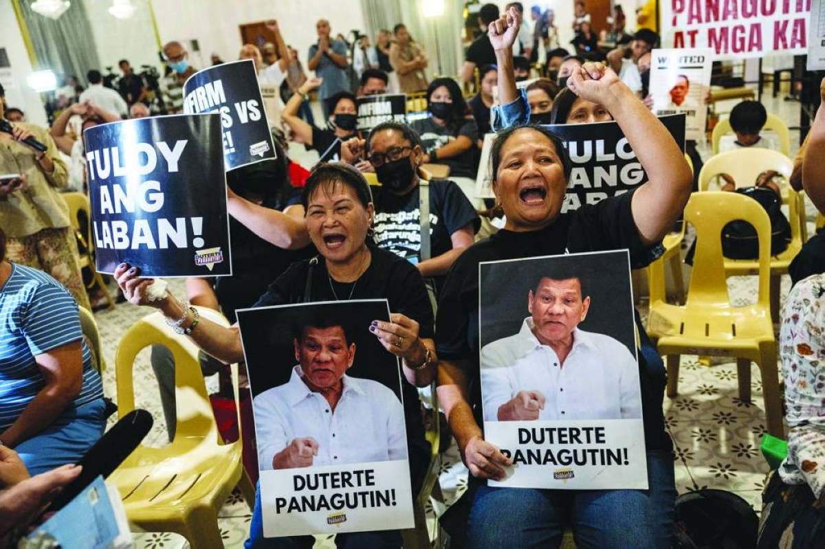 Relatives of drug war victims holding placards that say "the fight continues" and "make Duterte accountable" in Filipino, react after watching a livestream of the International Criminal Court's rejection of former Philippine President Rodrigo Duterte’s challenge to the court’s jurisdiction over his alleged crimes against humanity charges, in Quezon City, Philippines,on Wednesday. (Reuters)