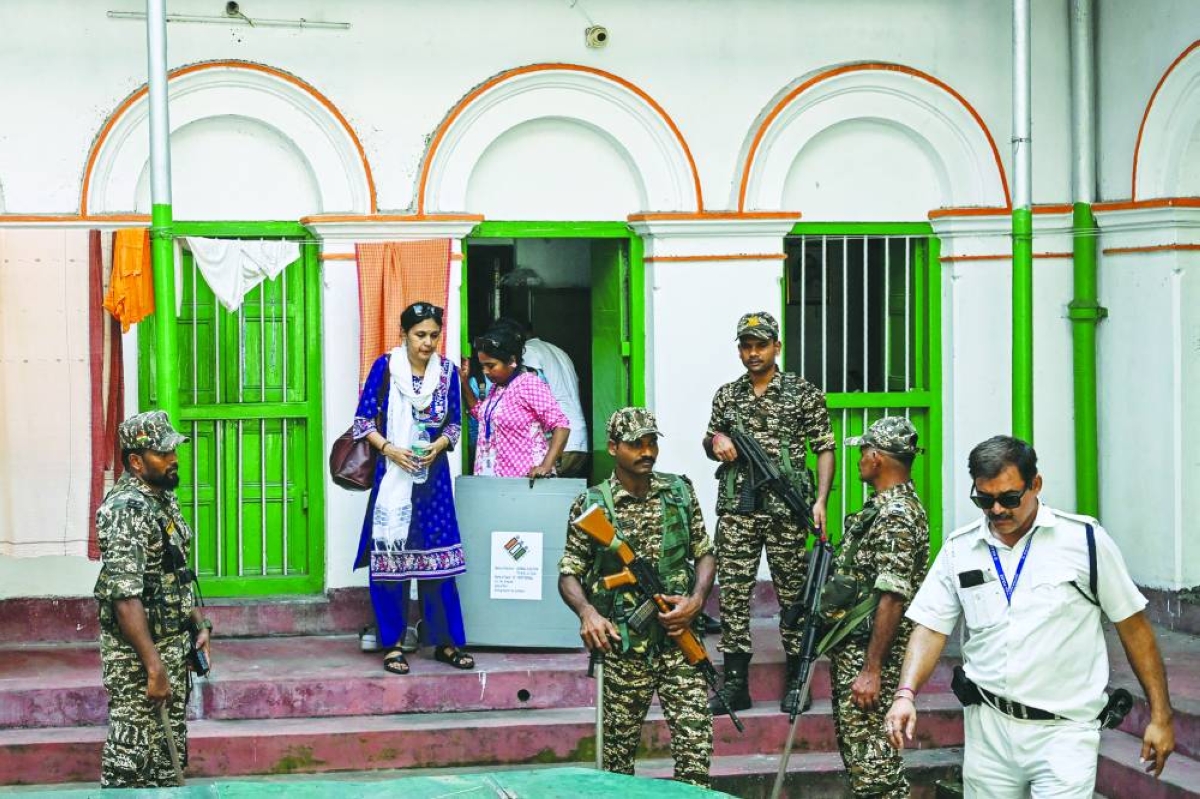 Security personnel and polling officials leave the home of an elderly voter after collecting their ballot through the home-voting process during the West Bengal Legislative Assembly elections in Kolkata Thursday. ( AFP)