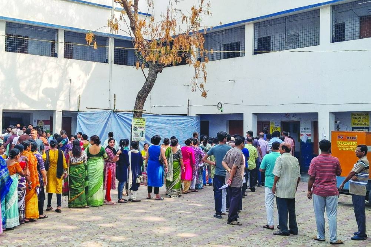 People queue up to cast their votes outside a polling station during the West Bengal Legislative Assembly elections in Berhampore, Murshidabad district, Thursday. (AFP)