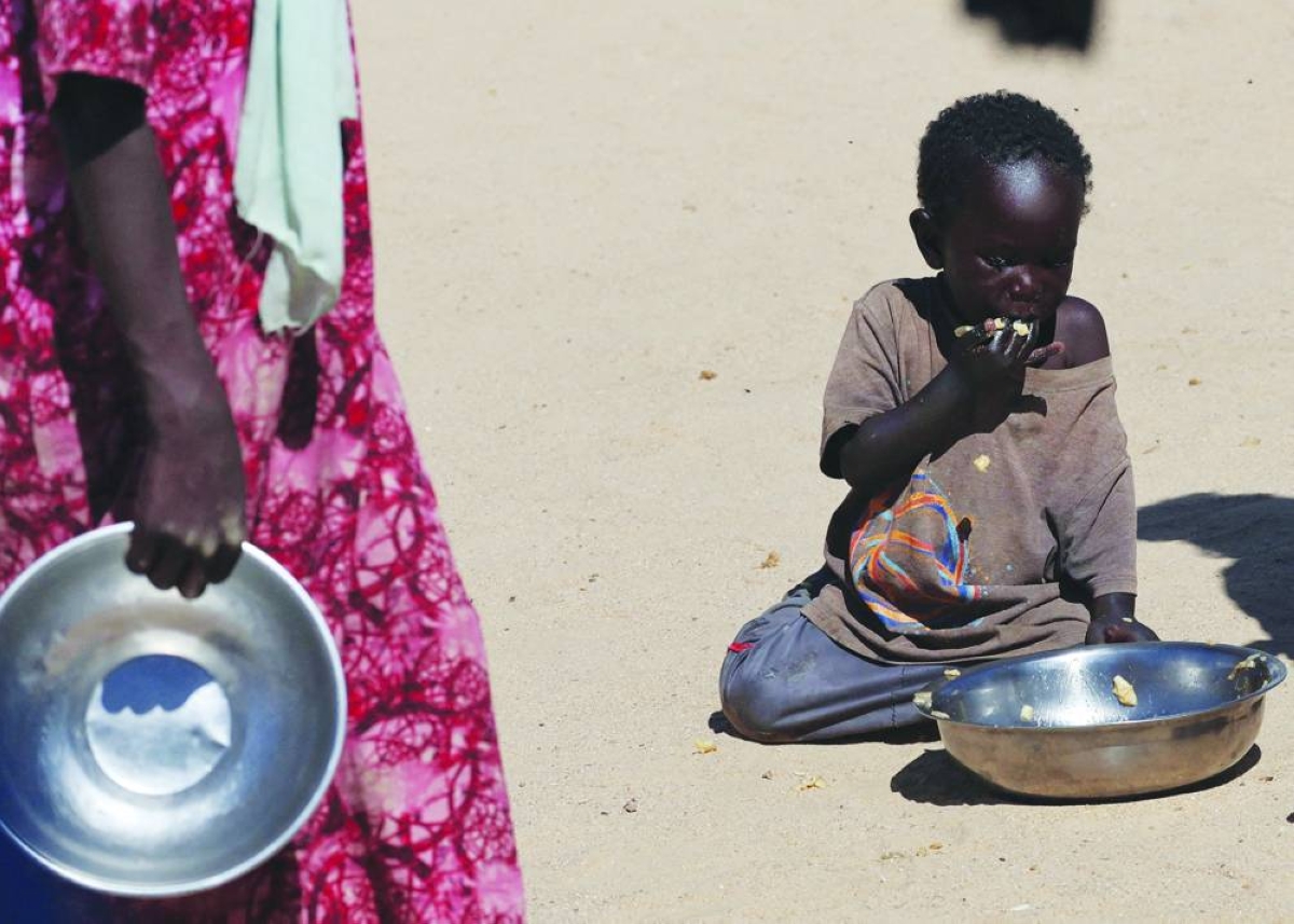 This picture taken last year shows a Sudanese orphaned child refugee from al-Fashir eating food provided by the ‘Group Kitchen Project’, inside the Tine transit camp in eastern Chad. – Reuters
