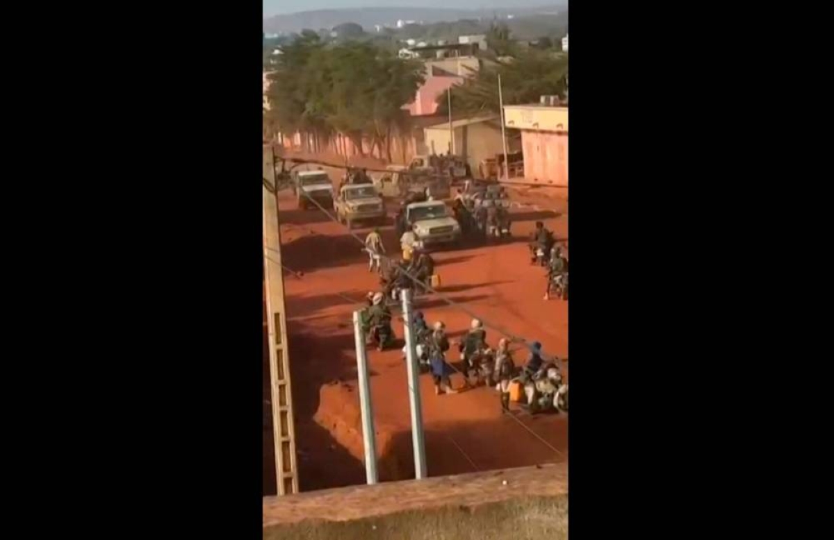 This video grab taken from UGC images verified by AFP show armed militants moving through the streets of Kati, the hometown of military ruler General Assimi Goita, as gunfire echoes across several cities of Mali. – AFP