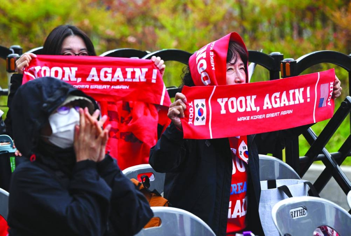 Supporters of South Korea's former president Yoon Suk-yeol and his wife Kim Keon-hee react as they watch a live stream of the trial of the former first lady on a street near the Seoul High Court in Seoul Tuesday. (AFP)