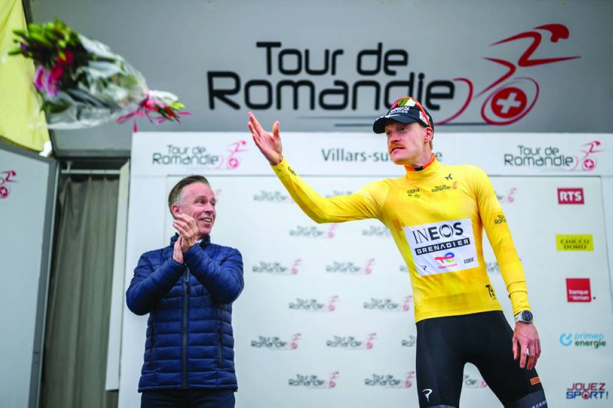 INEOS Grenadiers’ Dorian Godon throws flowers on the podium after winning the prologue of the Tour de Romandie UCI WorldTour cycling race in Villars-sur-Glane Tuesday. (AFP)