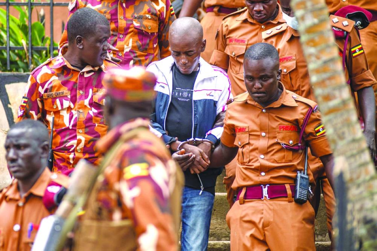 This picture taken last month shows Christopher Okello Onyum escorted by Uganda Prison guards during his trial at the Ggaba Community Church Grounds in Kampala. AFP