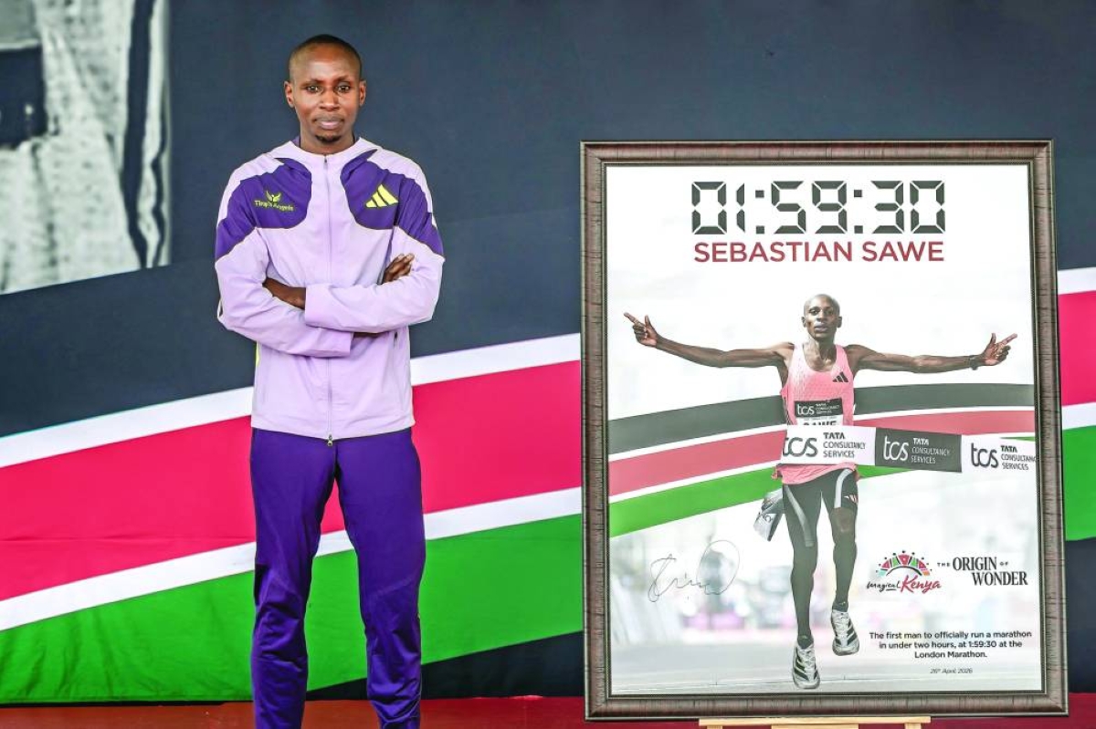 
Kenya’s Sabastian Sawe poses next to a picture of him while crossing the finish line to win the London Marathon after breaking a historic world record, during a congratulatory ceremony in Nairobi (AFP) 