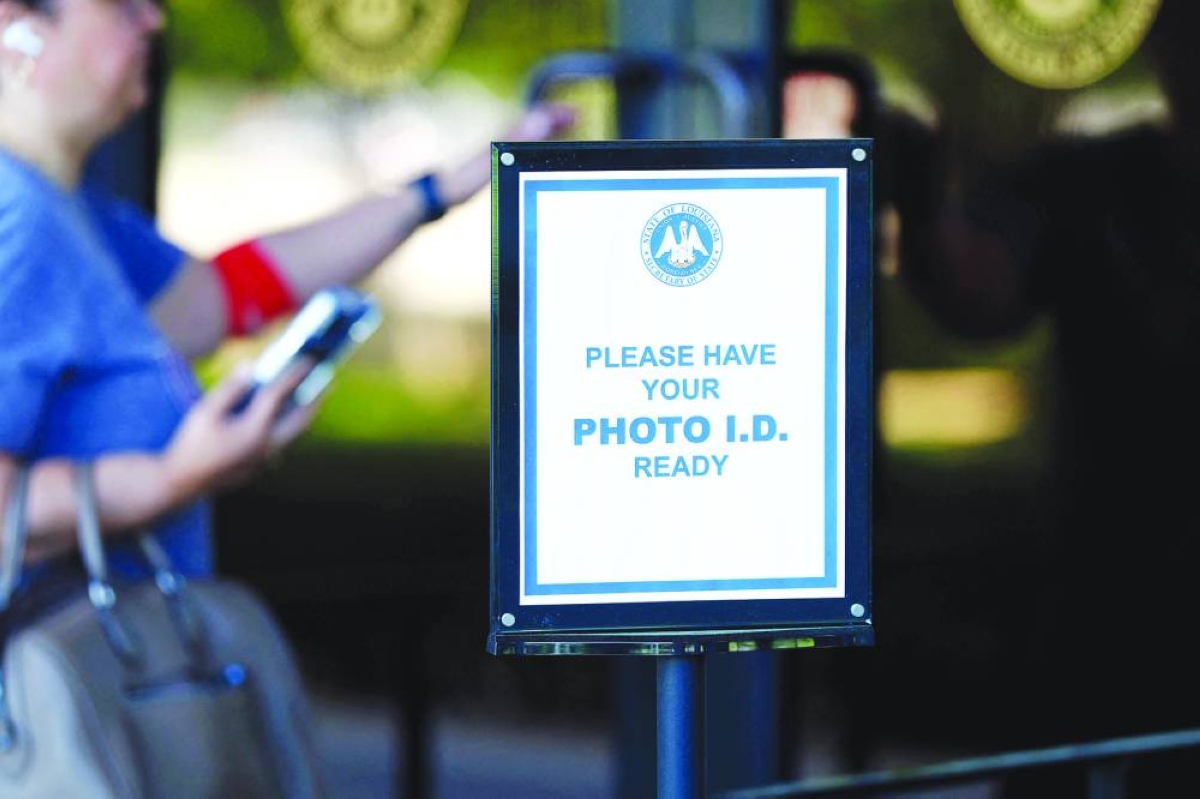 
A sign for voters to have photo ID ready is seen outside of the Louisiana State Archives in Baton Rouge, Louisiana. Early voting for Louisiana’s May 16 primaries began this week for US Senate and Louisiana state party candidates. However, Louisiana Governor Jeff Landry has postponed the state’s congressional primaries in light of a recent US Supreme Court decision that would give state lawmakers time to redraw congressional maps. (AFP) 